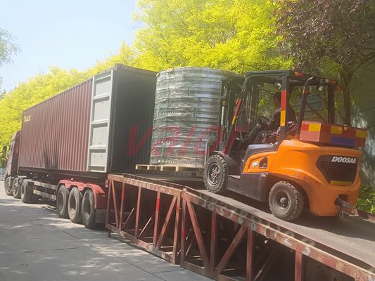 A pallet of metal plate structured packing is being loaded into a container.